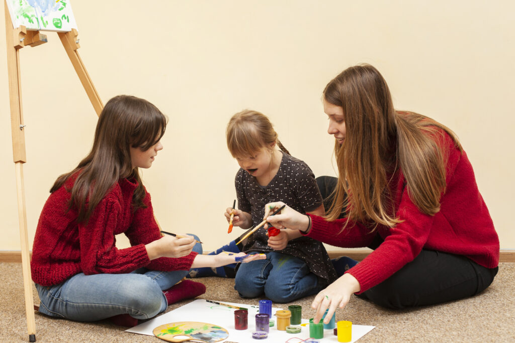 girl with down syndrome painting with colors