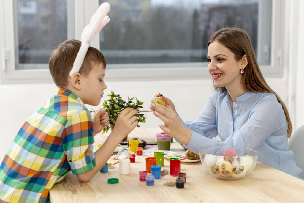 side view mother son painting eggs