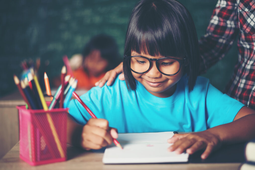 kid write a book in the classroom.
