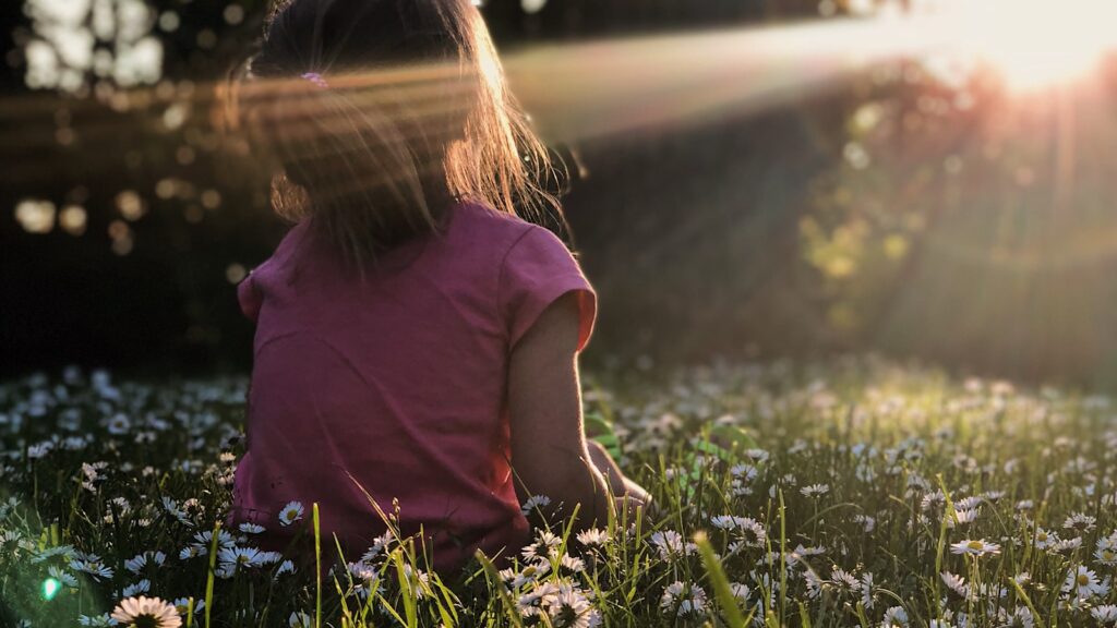 Child sitting calmly outdoors in nature during a pranic healing session for children with special needs in Bangalore